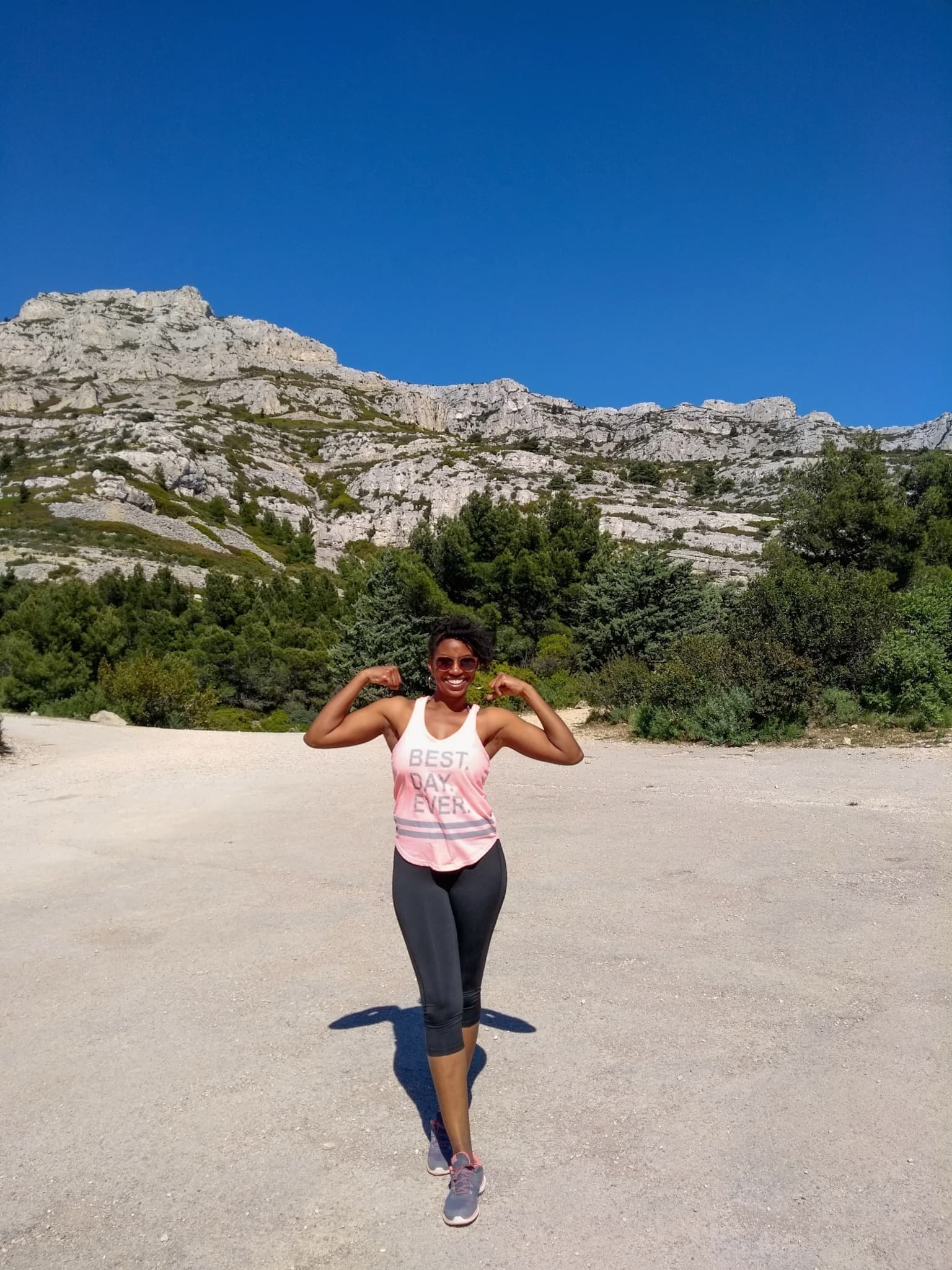 Image of a women who is living a great life and just hiked a mountain. Her shirt says best day ever!